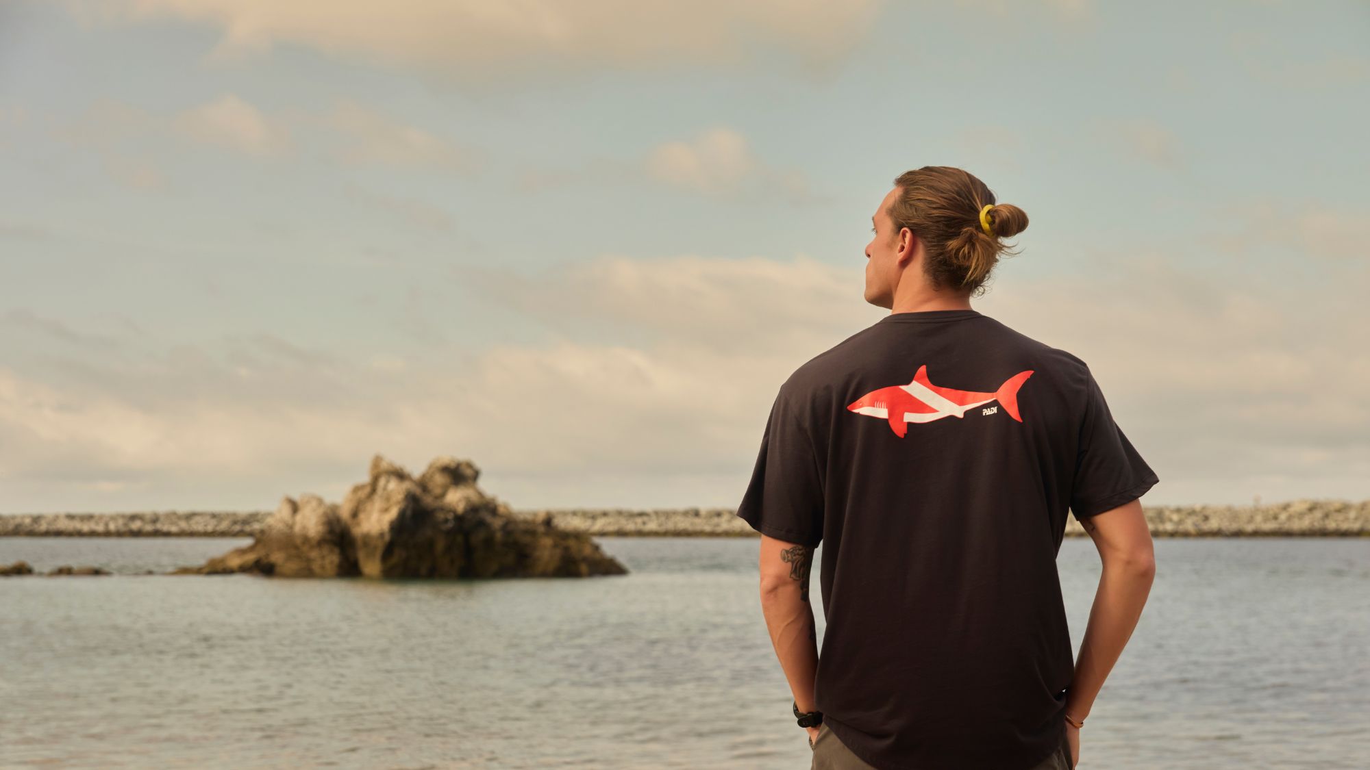 man wearing shark dive flag shirt