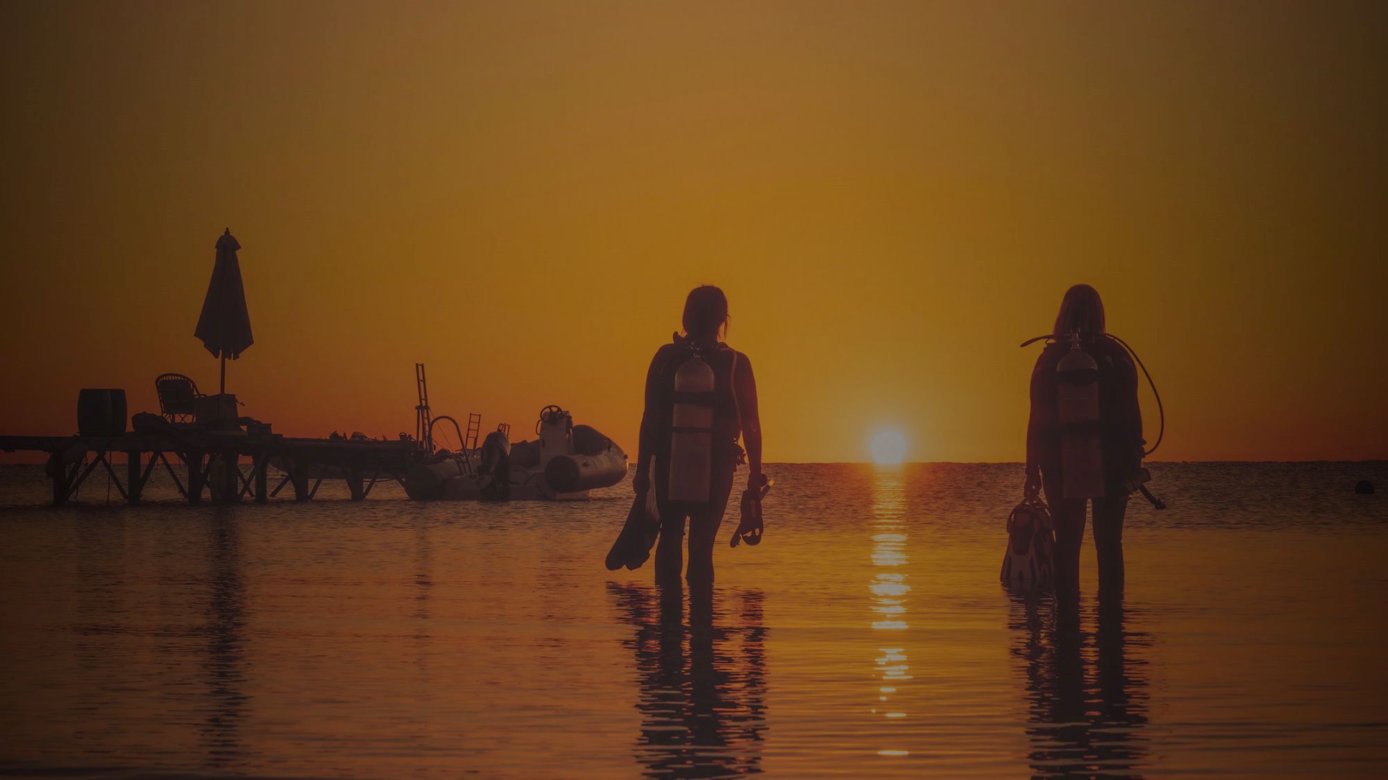 Scuba divers walking in the sunset 