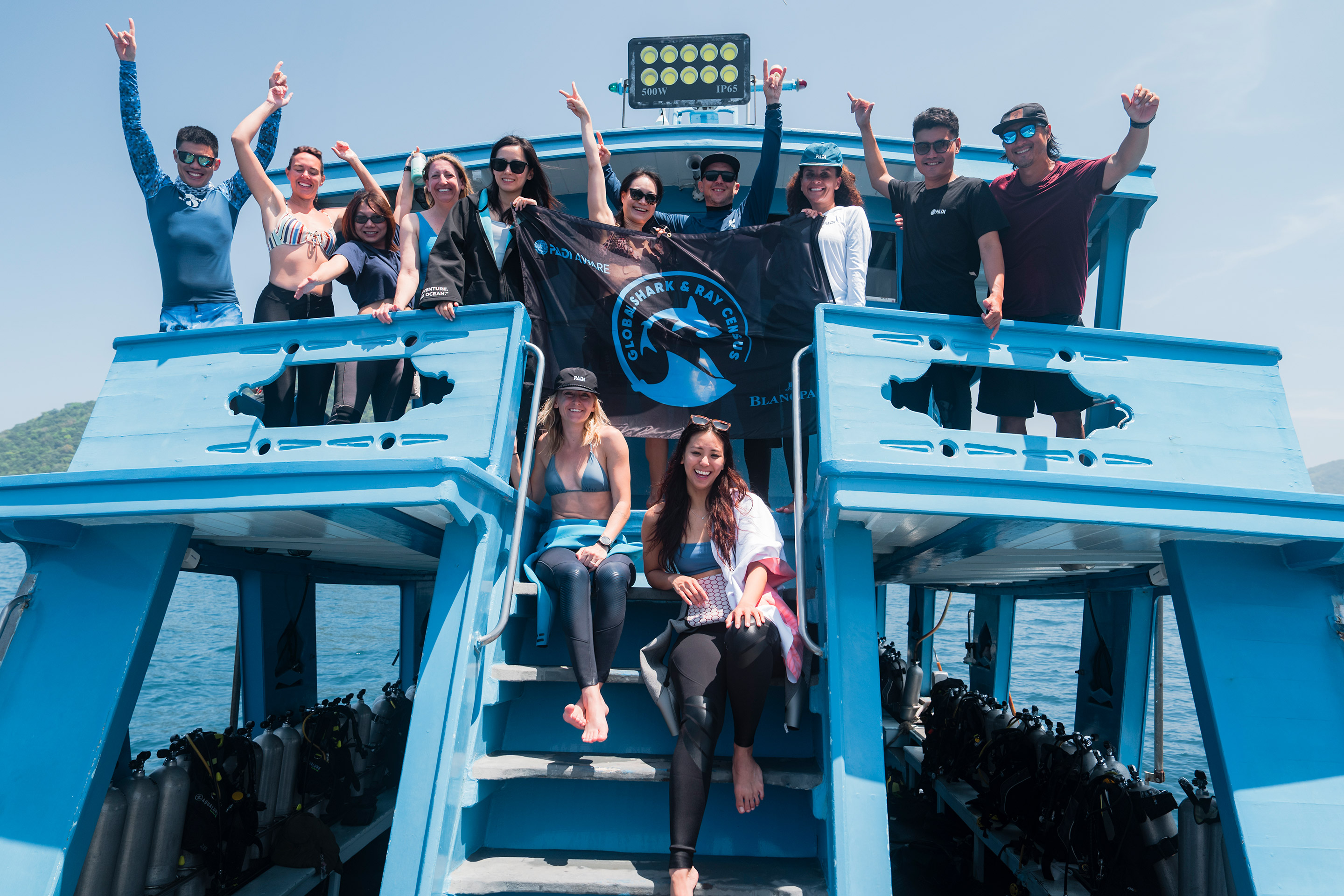 A group of people holding up a PADI AWARE flag