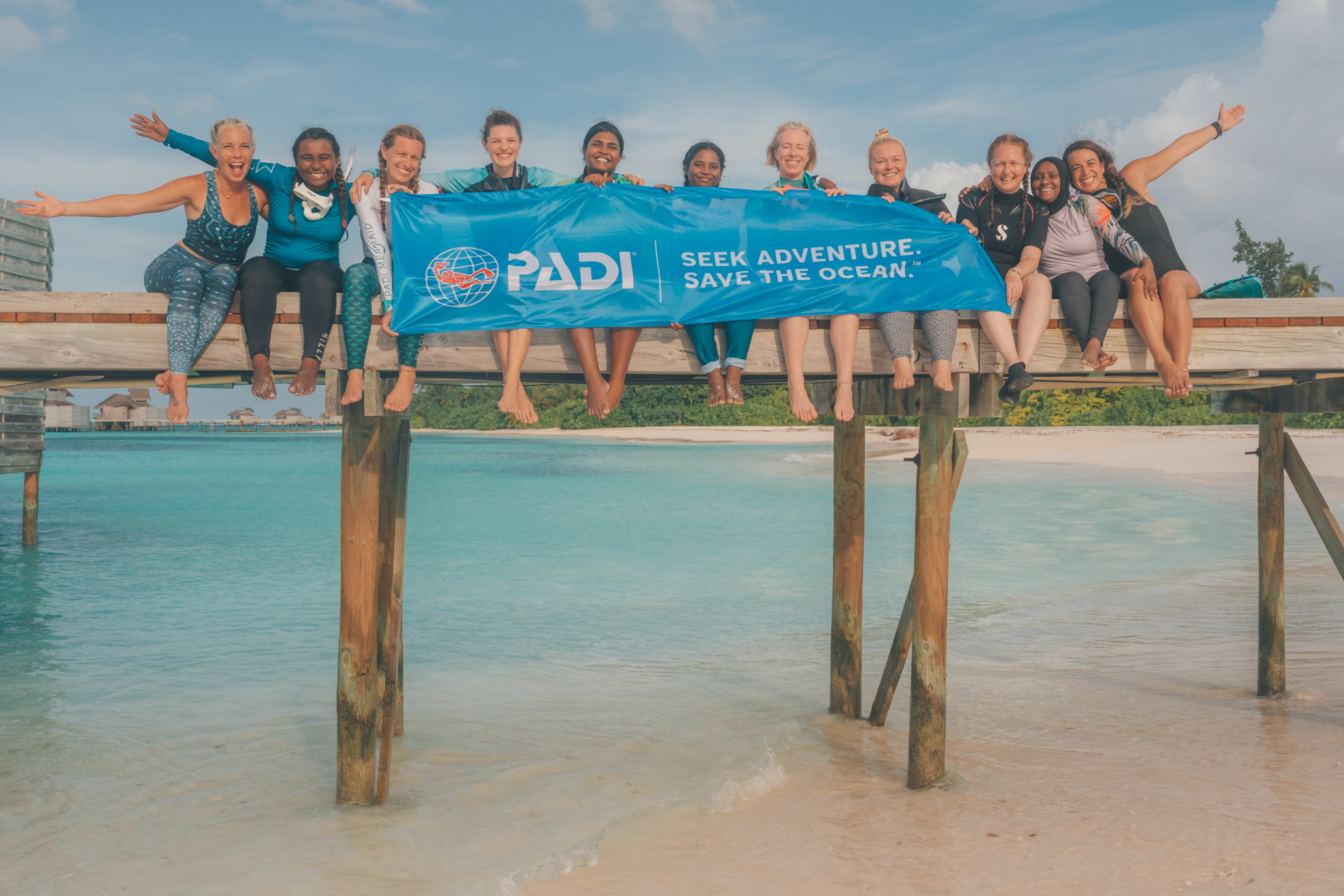 PADI banner hanging with a group of female divers