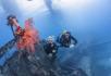 two divers swimming around a wreck