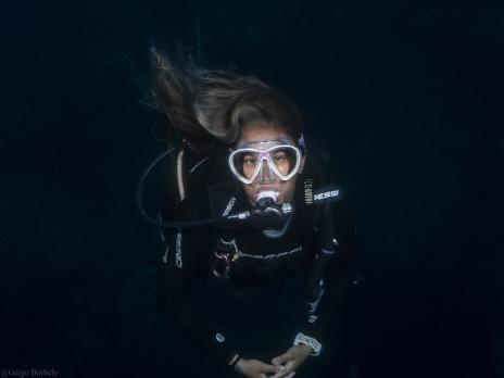 PADI AmbassaDiver Laura Quesada scuba diving in darkness.