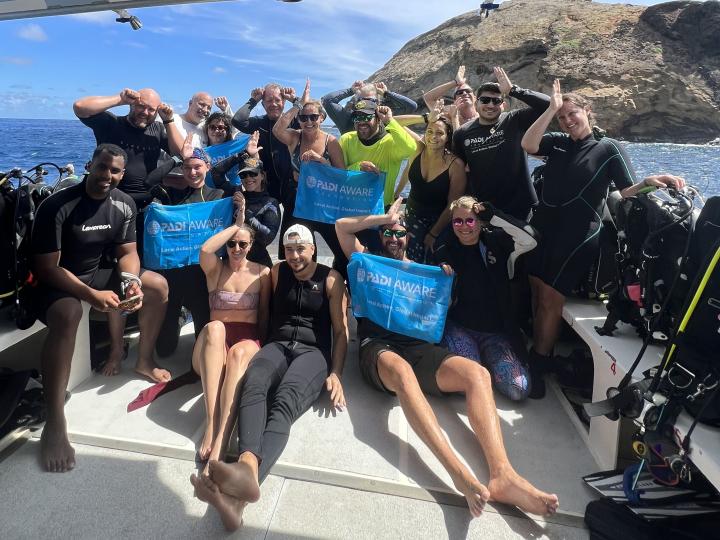 Divers holding AWARE Flags celebrating shark conservation
