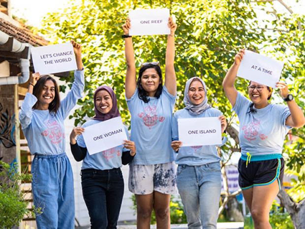 Five women holding up cue cards.