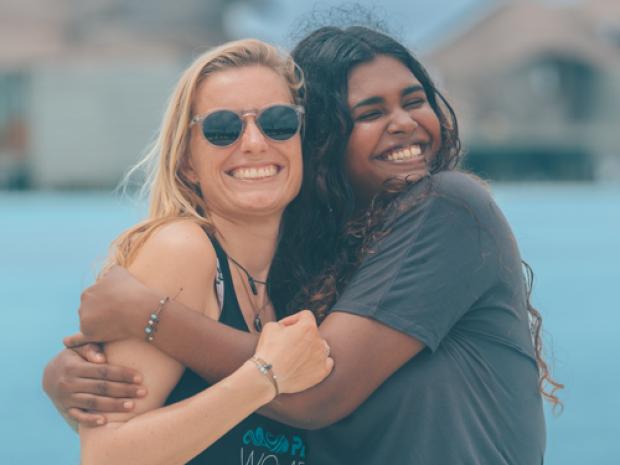 Two friends hugging and taking a picture.