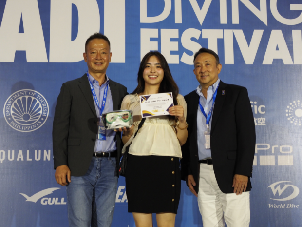 two male and one female on the stage for award