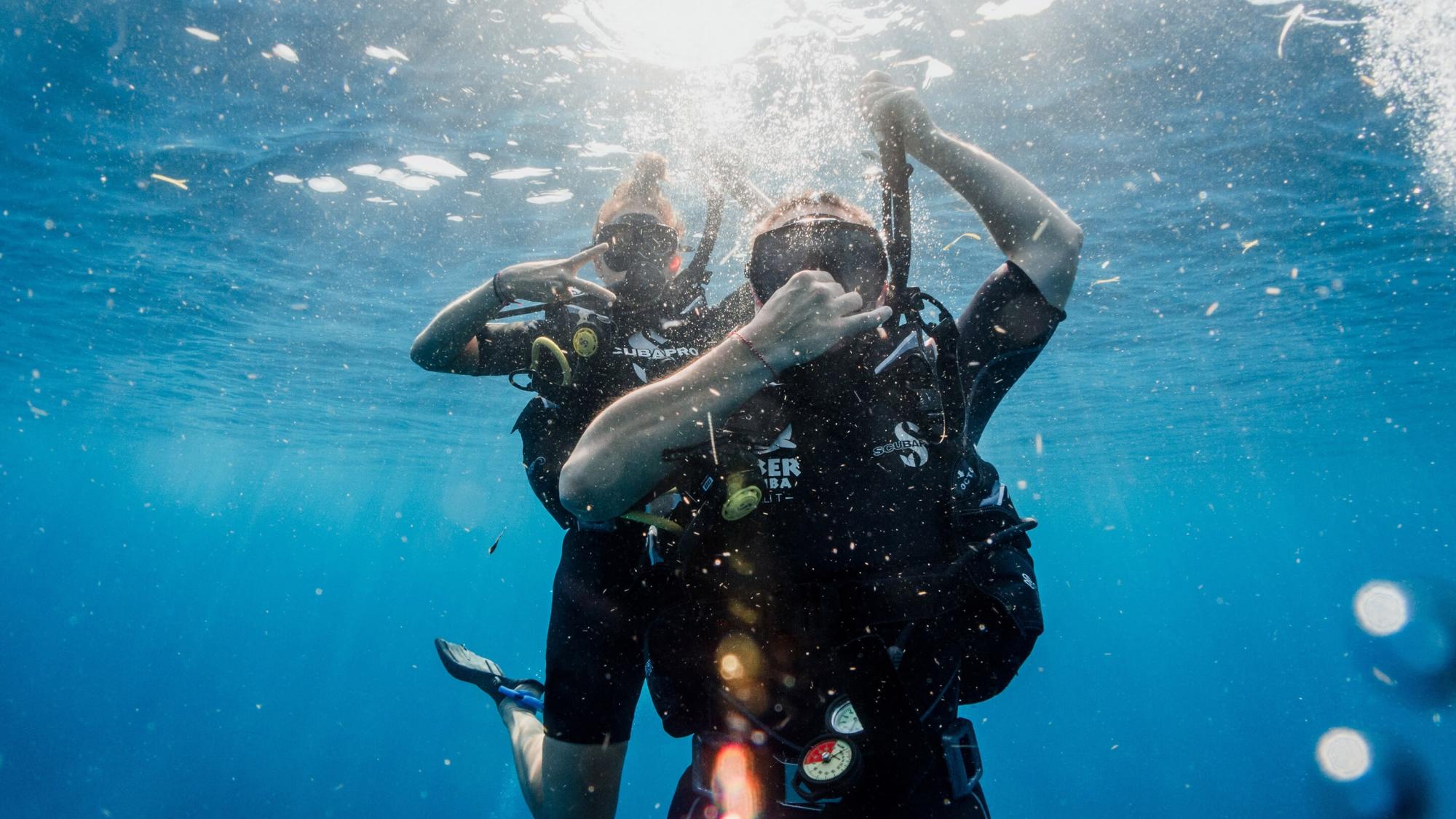 Two divers descending underwater