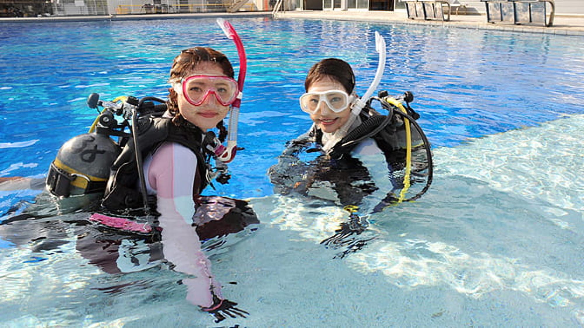プールでスキューバ ダイビングの練習をする女性