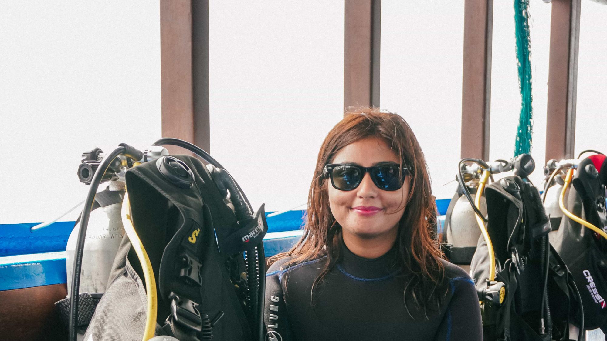 PADI AmbassaDiver Kritika Goel posing for a photo inside a boat.
