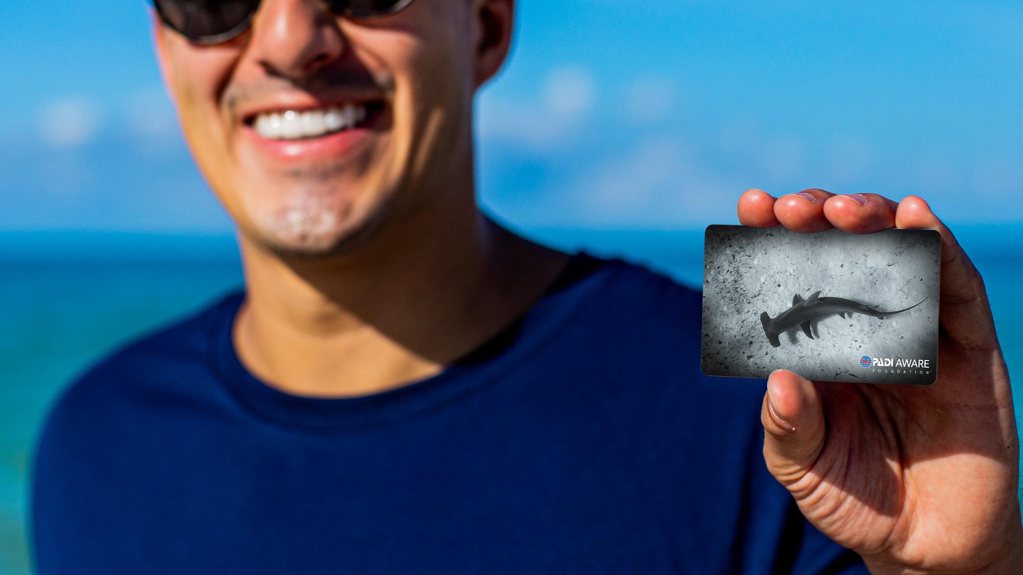 man holding a dive certification card